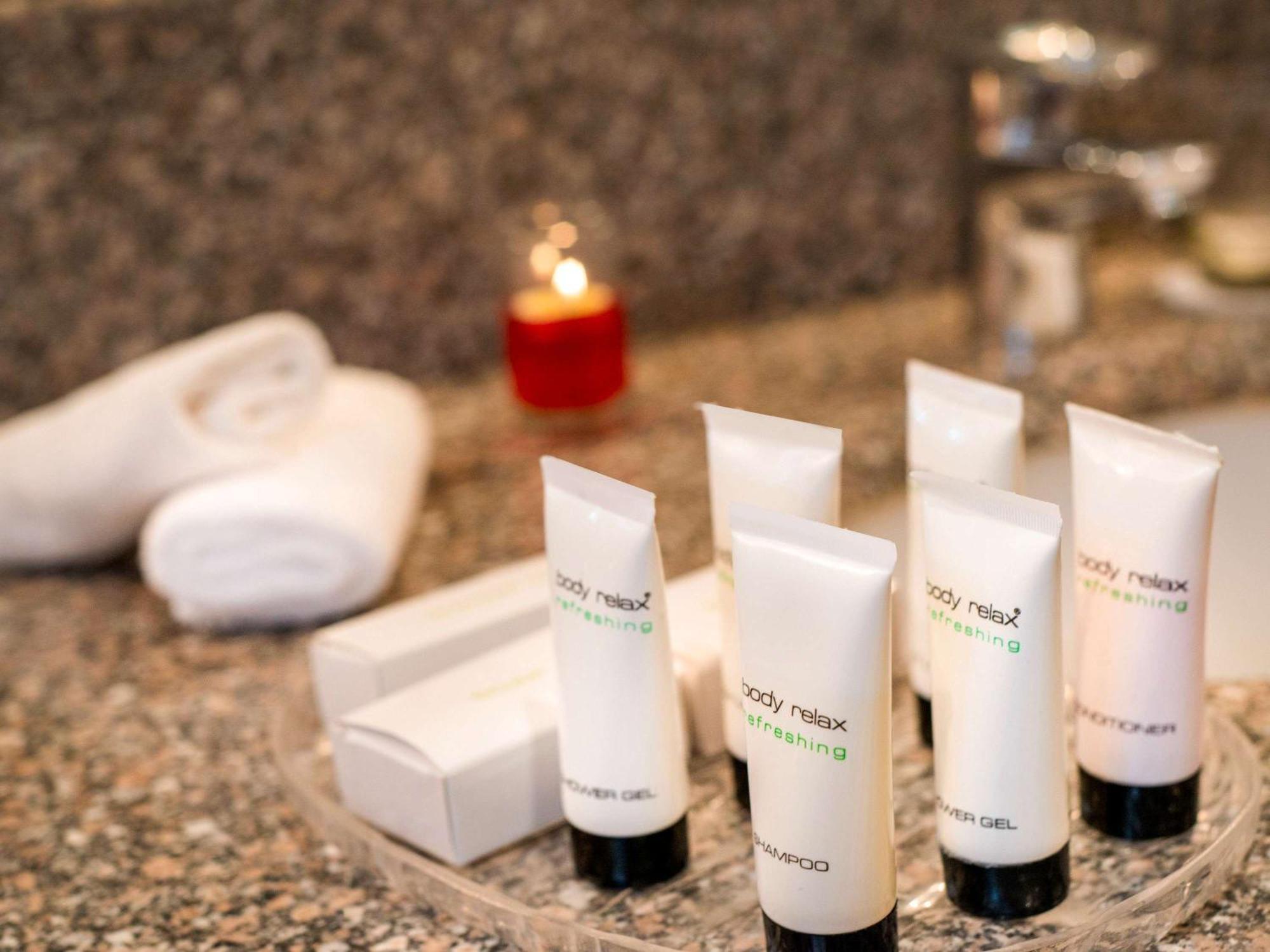 Movenpick Taba Resort & Spa Dış mekan fotoğraf The photo displays a selection of personal care products arranged on a countertop. There are several small tubes labeled "body relax" and "shampoo," which are presumably toiletries. Alongside them, there's a small white box, likely containing additio